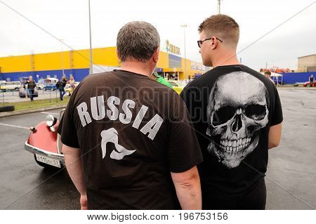 Orel Russia July 22 2017: Dynamica car festival. Men standing their backs to camera in t-shirts Russia and skull closeup