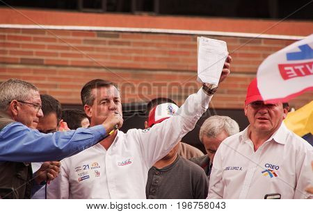 Quito, Ecuador - April 7, 2016: Closeup opposition leader Andres Paez surrounded by people and holding in his hands proofs of election fraud, police and journalists during anti government protests in Shyris Avenue.