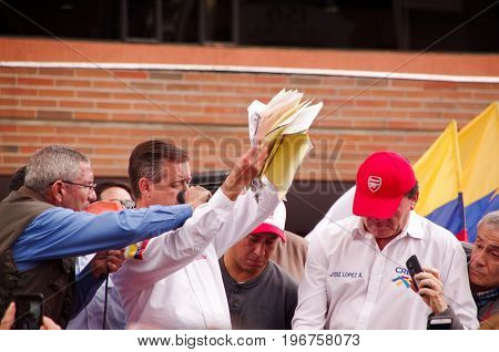 Quito, Ecuador - April 7, 2016: Closeup opposition leader Andres Paez surrounded by people and holding in his hands proofs of election fraud, police and journalists during anti government protests in Shyris Avenue.