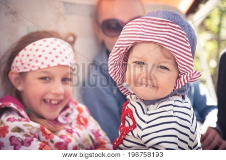 Funny cheerful baby with family outdoors symbolizing happiness