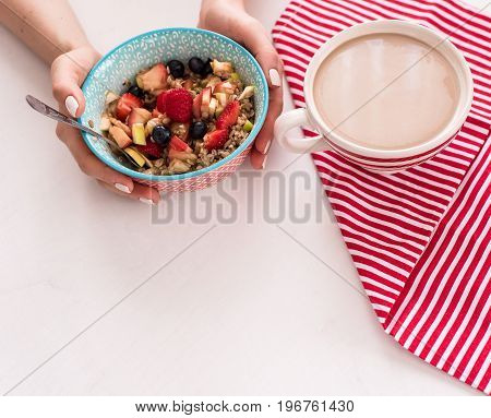 Healthy breakfast - cup of coffee, muesli and fresh berries on white wooden background, top view, health concept