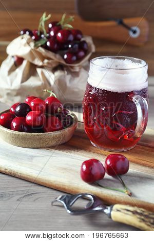 Light fruit craft beer and cherry on wooden chopping board rustic style