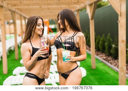 Back View Beautiful Sexy Women In Bikini Drinking A Cocktails While Relaxing In The Swimming Pool. S