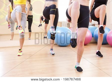 Sport Concepts. Closeup of Legas of Four Caucasian Female Athletes Having Body Stretching Exercises in Sport Gym.Horizontal Image Composition