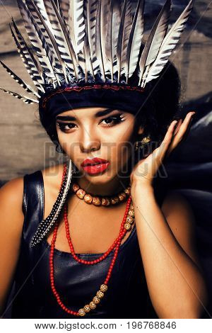 young pretty woman with make up like red indian, futher in hair, fashion hallowen concept creative