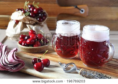 Light fruit craft beer and cherry on wooden chopping board rustic style