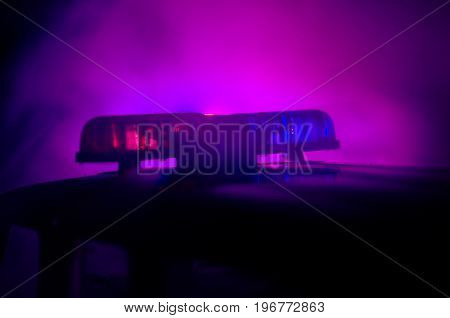 Red Light Flasher Atop Of A Police Car. City Lights On The Background. Police Government Concept