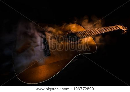 Music Concept. Acoustic Guitar Isolated On A Dark Background Under Beam Of Light With Smoke With Cop