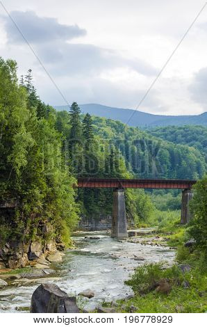 picturesque place, a mountain river with a rapid current of rocks and a bridge
