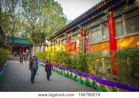 HONG KONG, CHINA - JANUARY 22, 2017: Unidentified people walking through the enter of Wong Tai Sin Buddhist Temple to pray, in Hong Kong, China.