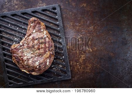 Barbecue dry aged Rib of Beef as top view on a grillage 