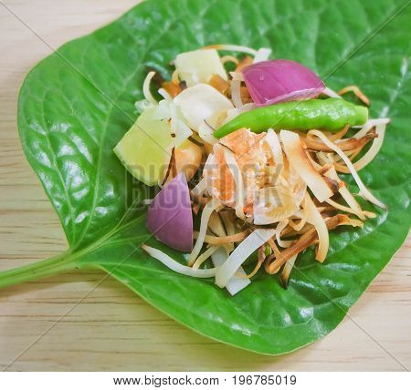 Thai Traditional Snack and Dessert Close Up Dish of Miang Kum or Sweet and Spicy Betel Leaf Wrap Filled with Coconut Peanuts Dried Shrimp Chiles and Lime.