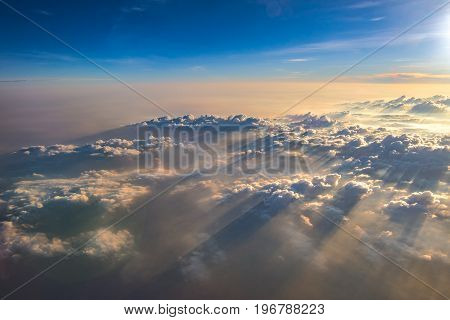 Clouds view from airplane window with sunlight.