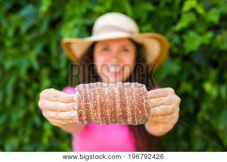 Close-up of young female tourist with traditional czech dessert trdelnik in Prague. Czech Republic. Outdoor.
