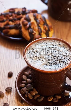 Kopp kaffe och choklad kaka på bordet