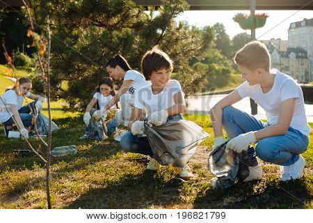 Believe in yourselves. Two young men communicating with each other while relaxing and keeping smile on their faces