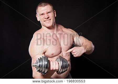 Sport the athlete bodybuilder shakes their muscles dumbbells