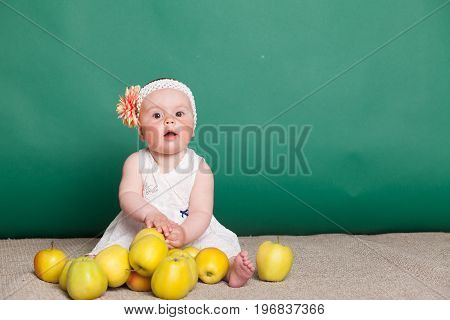 baby girl in a dress with Green apples 1