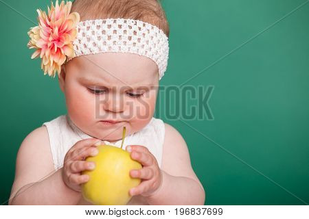 baby girl in a dress with Green apples 1