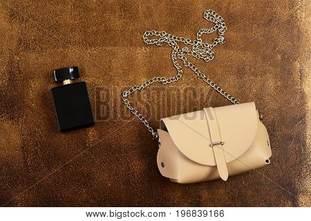 Leather Purse And Perfume Bottle On Brown Suede Background