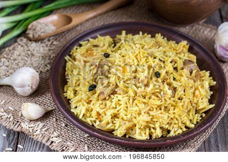 Traditional uzbek meal called pilaf on a wooden background