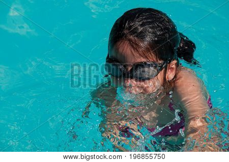 Penedo, Brazil - January 18, 2015. Child swimming in blue pool on sunny day in Penedo, a tourist town founded by Finns with strong influence of this culture. Rio de Janeiro State, southwestern Brazil