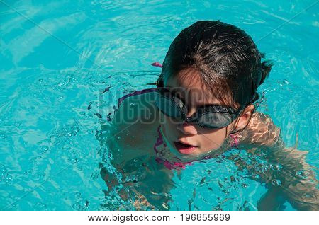Penedo, Brazil - January 18, 2015. Child swimming in blue pool on sunny day in Penedo, a tourist town founded by Finns with strong influence of this culture. Rio de Janeiro State, southwestern Brazil