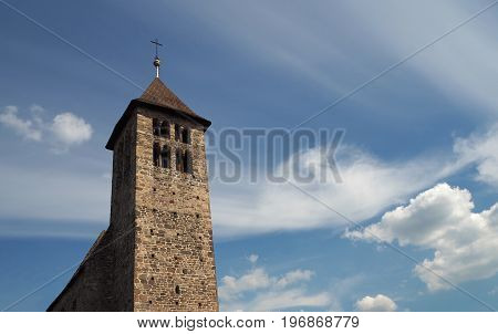 Old Stone Church Tower On The Dramatic Blue Clouds Background