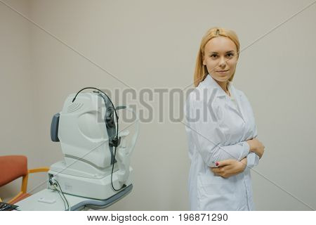 Portrait Of Young Beautiful Doctor/eye Specialist/optometrist In An Ophthalmologic Clinic Near Tomog