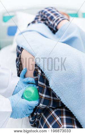 Doctor gives her patient for enema to resolve constipation problem.