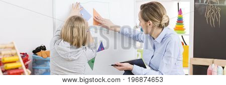 Young professional teacher finding an autism in her young student