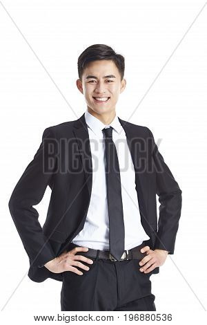 studio portrait of a young asian businessman in formal wear arms akimbo isolated on white background.