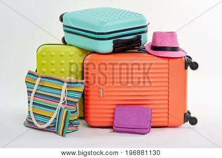 Clutch bag, pink hat, suitcases. Woman summer pocketbook and beach accessories.