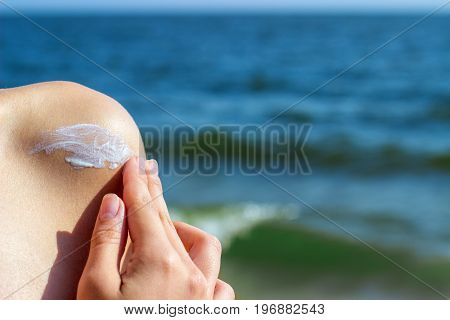 Girl applying sun lotion on the beach