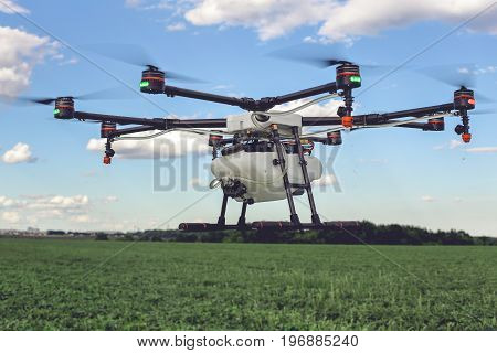 Drone flying above beautiful landscape green field. Hovering drone flies in blue sky and taking pictures of green hills.