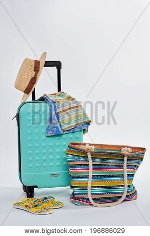 Summer accessorries for beach. Bright clothes and suitcase.