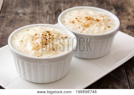 Arroz con leche. Rice pudding with cinnamon on wooden background