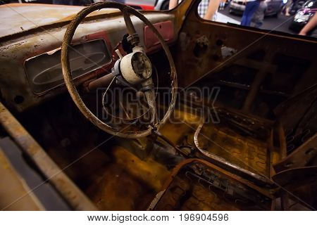 Rusty interior of an old car. Close up of Car steering wheel and dashboard panel with rust and dust.