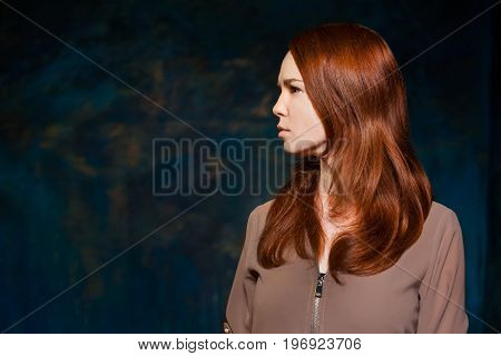 Dissatisfaction red-haired girl in brown shirt. beauty model woman with luxurious red hair. hairstyle. holiday makeup