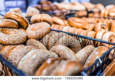 Closeup of many bagels in bakery on display