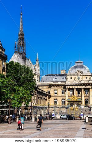 Paris France - July 04 2017: Tourists in front of the Palace of Justice (Palais de Justice) with decorative wrought-iron lattice fence. The Holy Chapel (Sainte Chapelle) is a royal chapel in the gothic style.