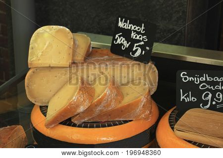 Traditional Dutch cheeses on display in a store (text on labels: price and product information in Dutch)