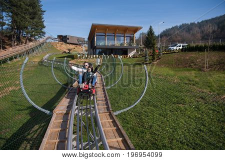 Excited young couple enjoys driving on alpine coaster