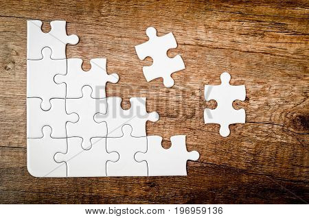 Placing missing piece of puzzle on wooden background