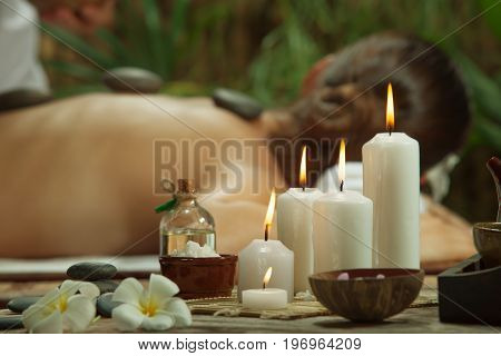 portrait of young beautiful woman in spa environment. focused on candles.