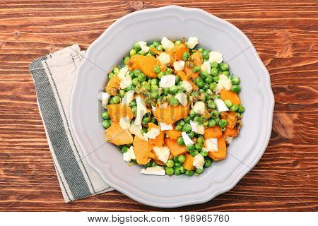 Warm salad with roasted pumpkin, peas and cheese brie. Low fat healthy eating concept.