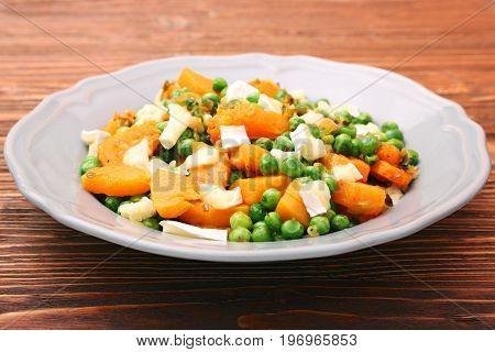 Warm salad with roasted pumpkin, peas and cheese brie. Low fat healthy eating concept.