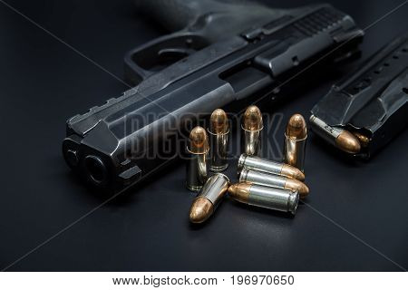 9 mm Pistol bullets and magazine on black background. Gun isolated