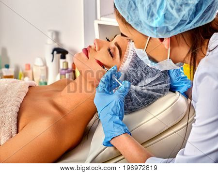 Filler injection for female forehead face. Plastic aesthetic facial surgery in beauty clinic. Beauty woman giving injections. Doctor in medical gloves with syringe injects cheeks drug. Facelift.