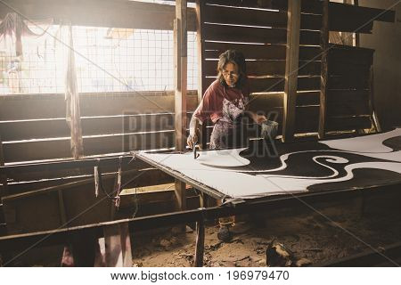 Kota Bahru Kelantan Malaysia 15th July 2017 - A shot of a local Kelantanese woman coloring the batik outlined by wax. The shot was taken at one of the villages in Kelantan that practices the traditional ways of producing batik fabrics.